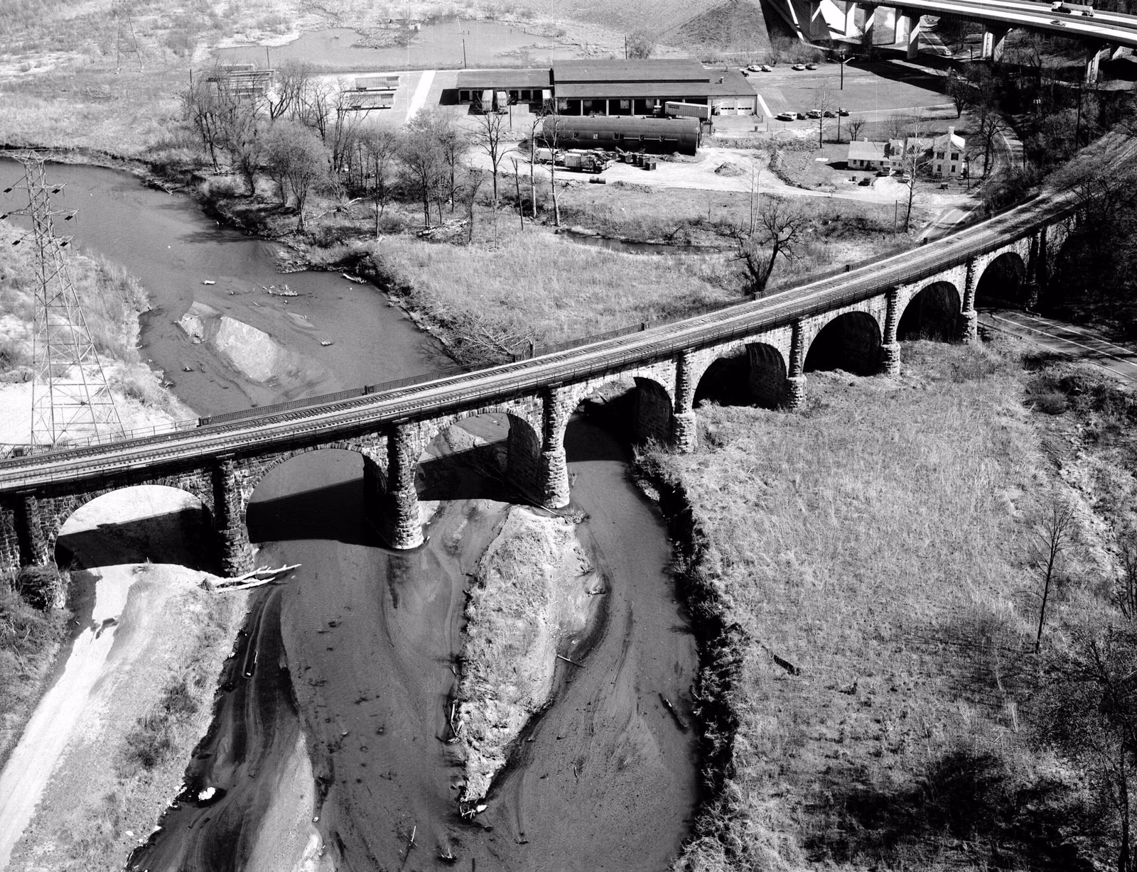 Black-and-white 1977 aerial view of the curving Thomas Viaduct crossing the Patapsco River