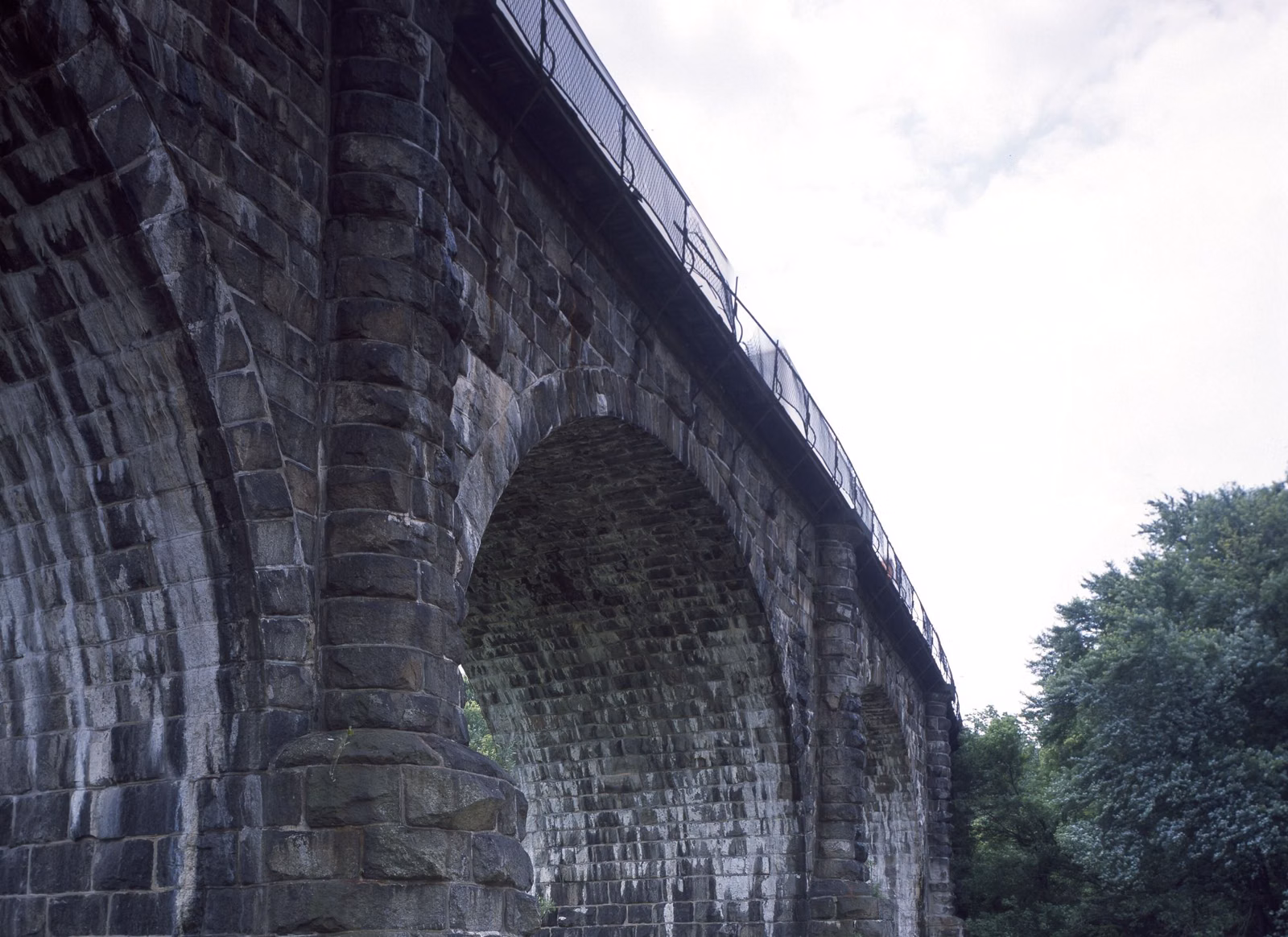 The stone arches of the Thomas Viaduct seen from below, carrying the railroad over the Patapsco River valley